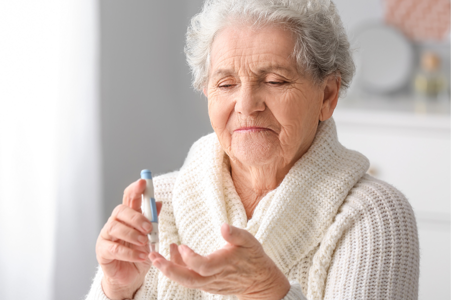 Image représentant une personne âgée diabétique qui se pique le doigt pour connaître sa glycémie.