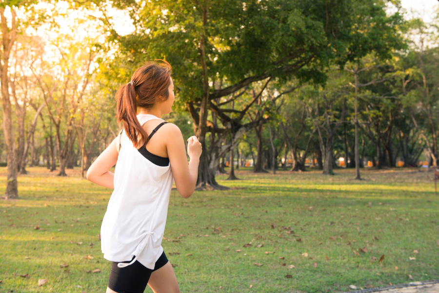 Femme en train de courir dans un parc.