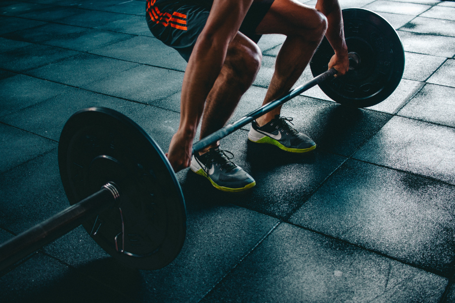 Homme en train de se préparer à soulever une altère en salle de sport. sport et microbiote