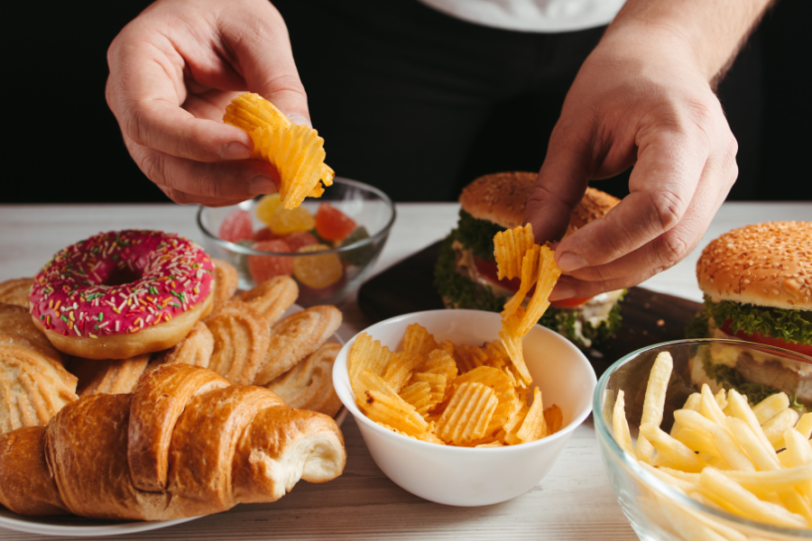 photo mettant en scene des bonbons viennoiseries hamburgers frites et chips