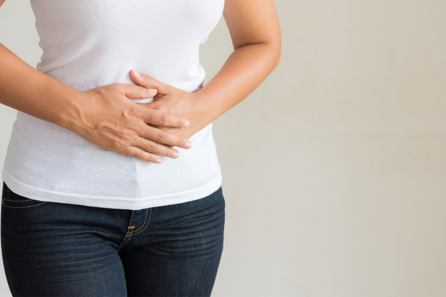 femme se tenant le ventre souffrant de troubles digestifs. anti nutriments et sante intestinale