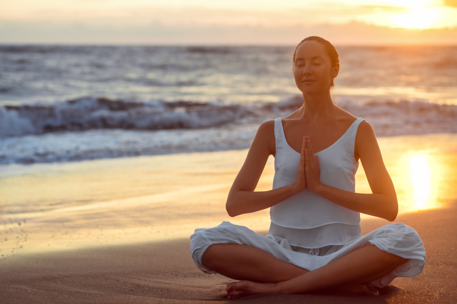 Femme en train de mediter sur la plage. Sclerose en plaques et microbiote