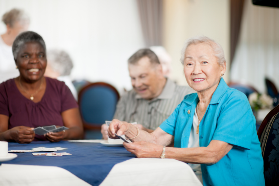 trois personnes seniors jouant aux cartes. microbiote et troubles cognitifs